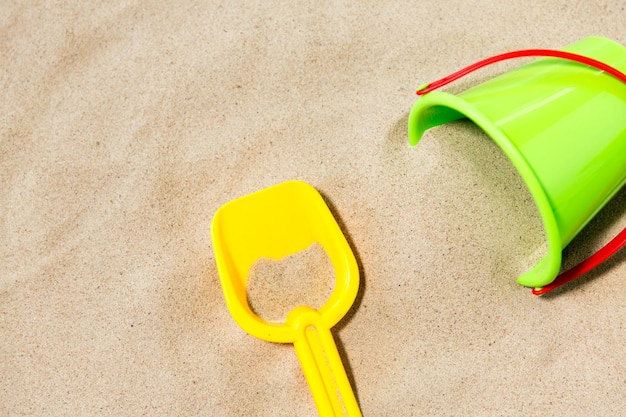 Foto vicino a un secchio di giocattoli e una pala sulla sabbia della spiaggia