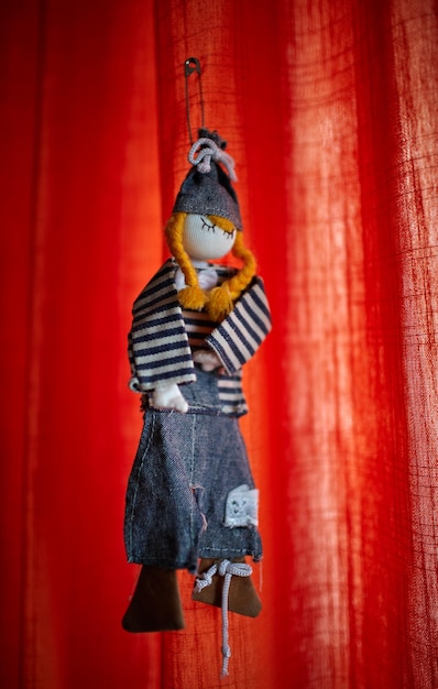 Close-up of toy hanging against red curtain