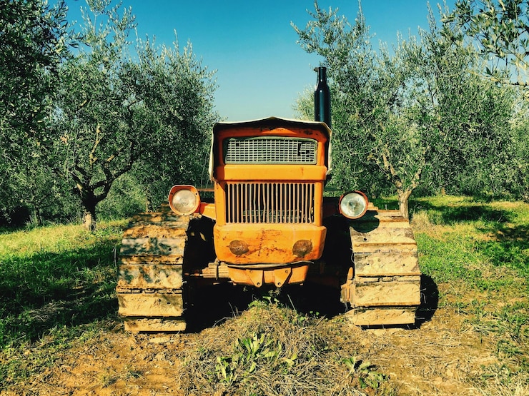 Photo close-up of tractor parked on field by trees