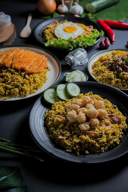 Закрыть традиционный жареный рис или индонезийскую еду Наси Горенг на черной тарелке с изолированным видом сверху