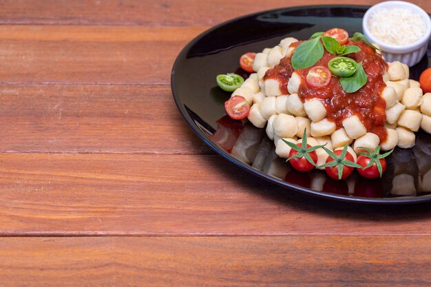 Close up on traditional italian potato gnocchi in tomato sauce with fresh basil and Cherry tomato