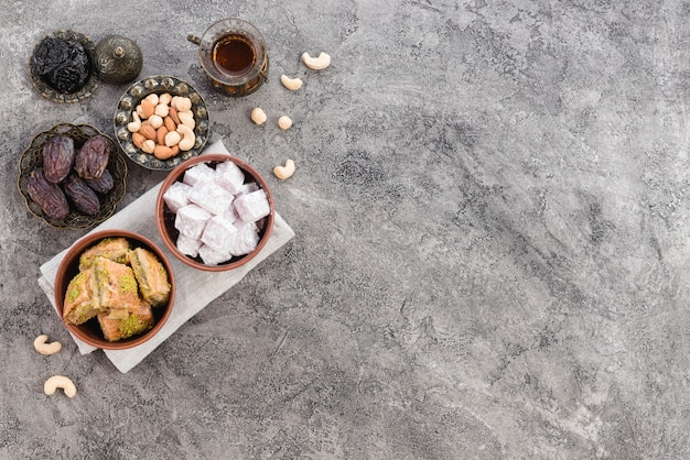 Close-up of traditional turkish delights lukum and baklava with dried fruits on gray concrete backdrop