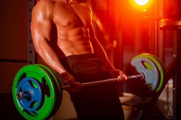 Close up training with barbell Man lifting barbells working out in gym Closeup deadlift barbells workout Sporty man lifts barbell in gym Workout the gym Athletic man with six pack perfect abs