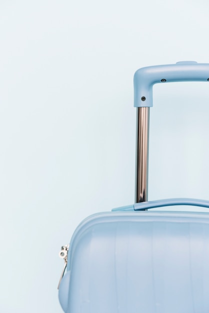 Primo piano di una borsa dei bagagli di plastica di viaggio su fondo blu
