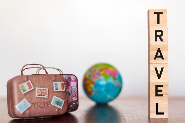 Photo close-up of travel text with luggage on table against white background