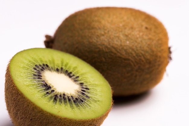 Un primo piano di due kiwi freschi su bianco