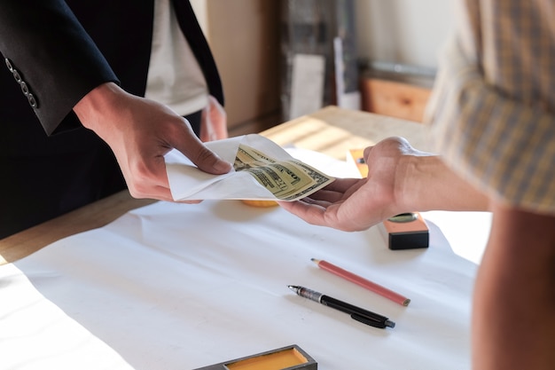 Close up two hands while paying money or bonus to worker and employee