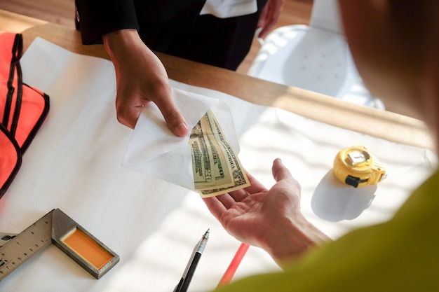 Close up two hands while paying money or bonus to worker and employee.