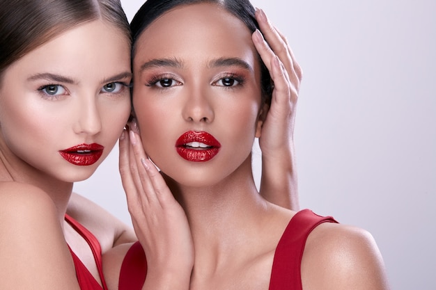 Close-up of two handsome girls, glamorous women looking to the camera