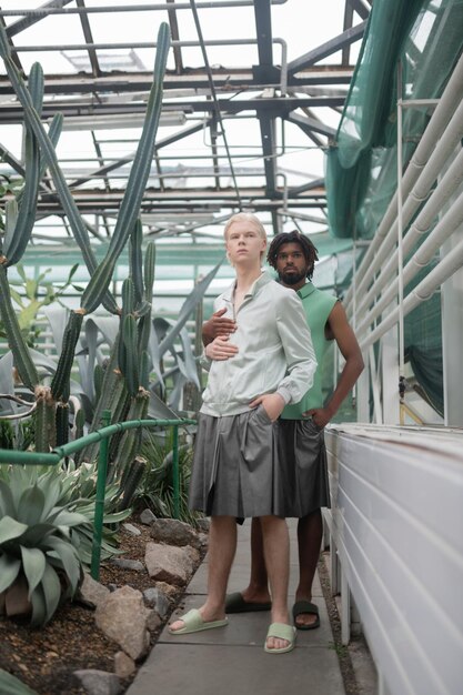 Close up of two male models wearing green shorts putting hands into pockets