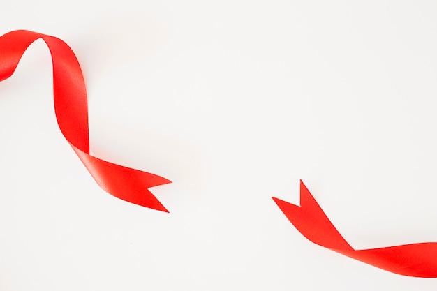 Photo close-up of two red ribbons on the corner of the background