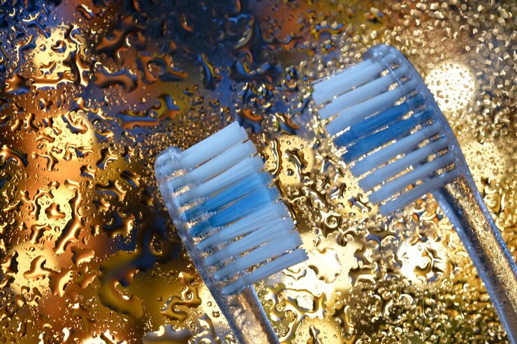 Photo close up of two toothbrushes on gold background