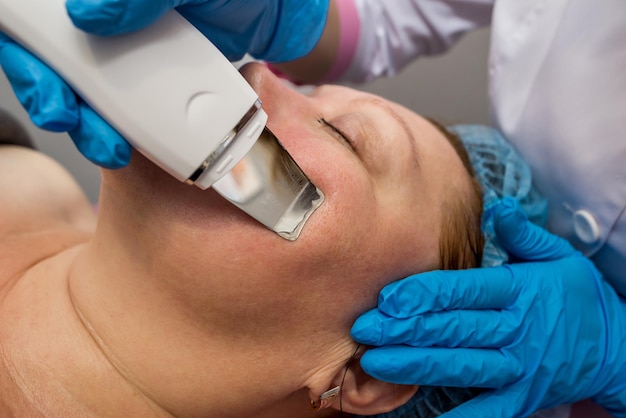 Close-up of ultrasonic face cleaning in a beauty salon. Facial care concept