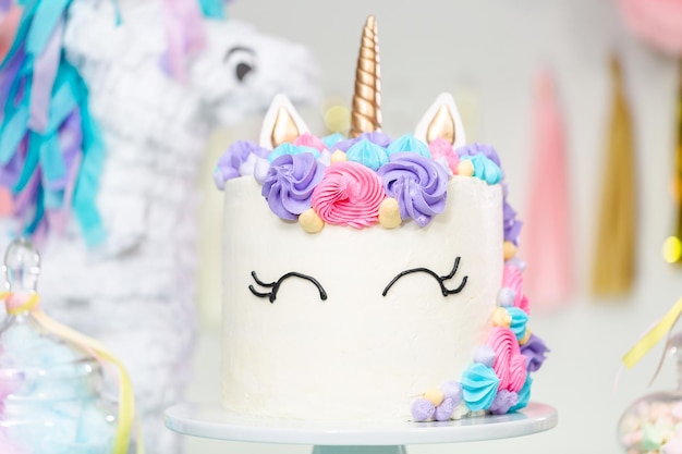 어린 소녀 생일 파티에서 유니콘 케이크를 닫습니다.