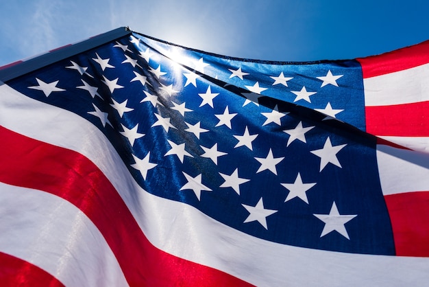 Close up United States of America flag on the blue sky background. 