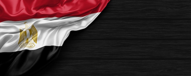 Photo close up of united states of egypt flag on the black wooden background 3d render