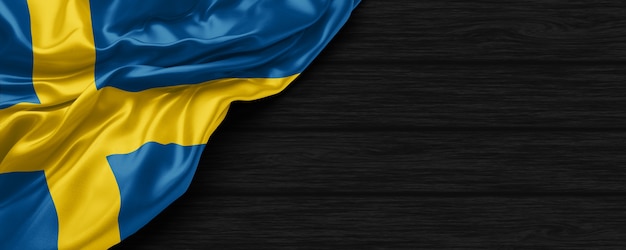 Close up of united states of Sweden flag on the black wooden background 3d render