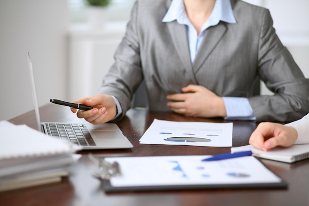 Close up of unknown business people at meeting discussing financial results