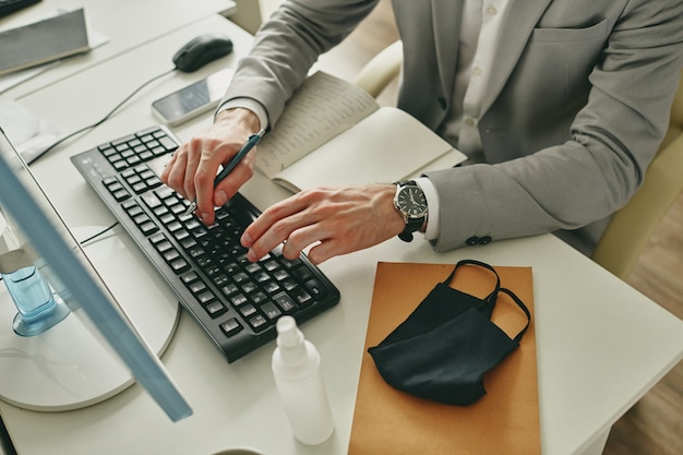 Close-up of unrecognizable businessman typing on computer keyboard