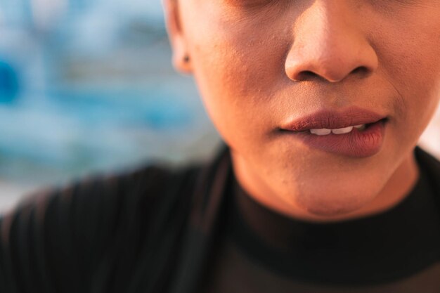 Close-up of unrecognizable girl biting her sensual and plump lips