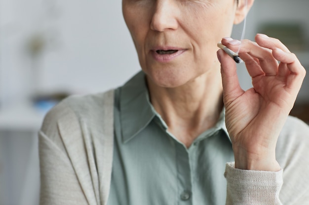 Close up of unrecognizable mature woman smoking cigarette at home for medicinal purposes, copy space