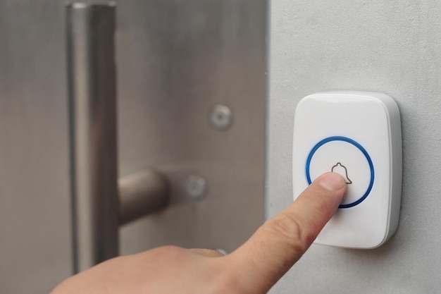 Close-up of using intercom. Hand presses the doorphone button