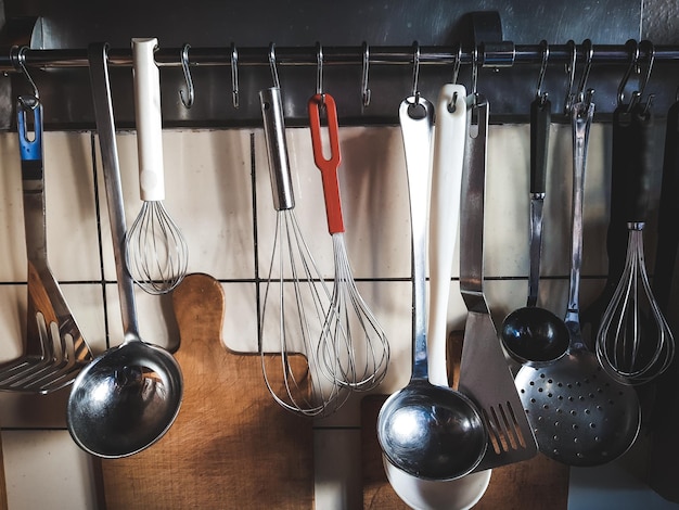 Close-up of utensils hanging on hooks in kitchen