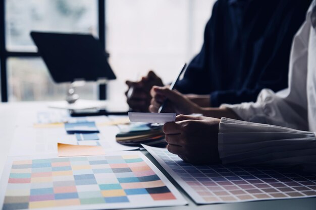 Photo close up ux developer and ui designer brainstorming about mobile app interface wireframe design on table with customer breif and color code at modern officecreative digital development agency