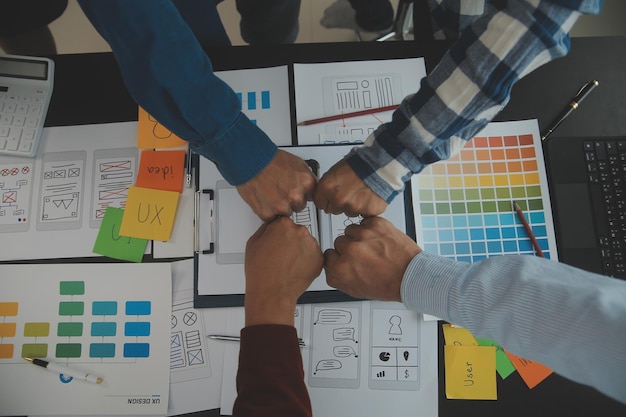 Photo close up ux developer and ui designer brainstorming about mobile app interface wireframe design on table with customer breif and color code at modern officecreative digital development agency