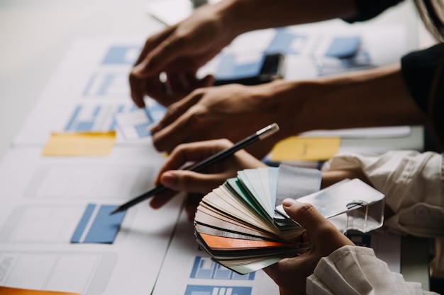 Close up ux developer and ui designer use augmented reality brainstorming about mobile app interface wireframe design on desk at modern officeCreative digital development agency