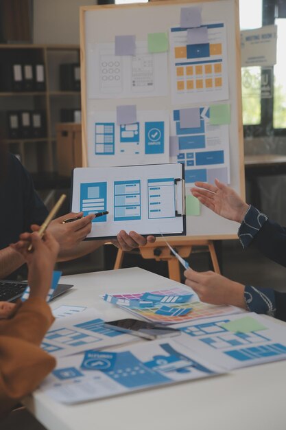 Close up ux-ontwikkelaar en ui-ontwerper gebruiken augmented reality brainstorming over mobiele app-interface wireframe-ontwerp op het bureau van een modern kantoorCreatief digitaal ontwikkelingsbureau