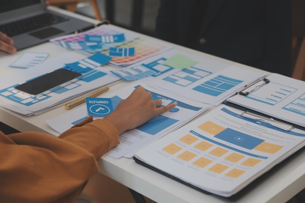 Close up ux-ontwikkelaar en ui-ontwerper gebruiken augmented reality brainstorming over mobiele app-interface wireframe-ontwerp op het bureau van een modern kantoorCreatief digitaal ontwikkelingsbureau