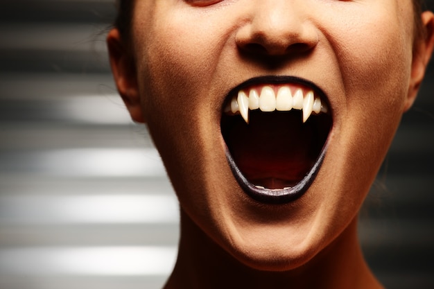 Close up of a vampire woman's mouth over dark background