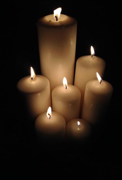 Foto close-up van aangestoken kaarsen in de donkere kamer