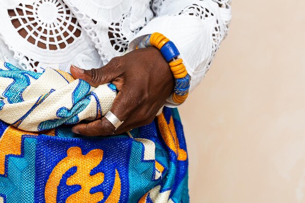 close-up van Afrikaanse handen in traditionele kleding met kleurrijke kralen