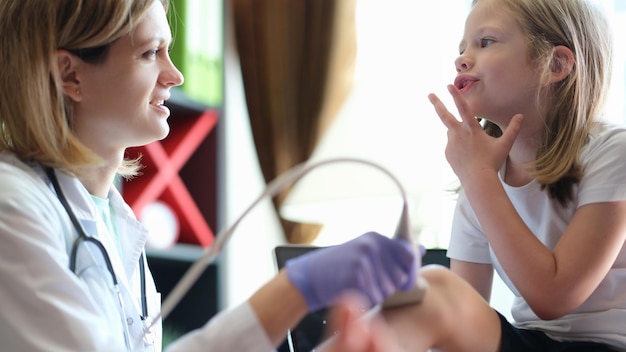 Foto close-up van arts die verwondingen of gebreken diagnosticeert van een klein meisje dat iets vertelt