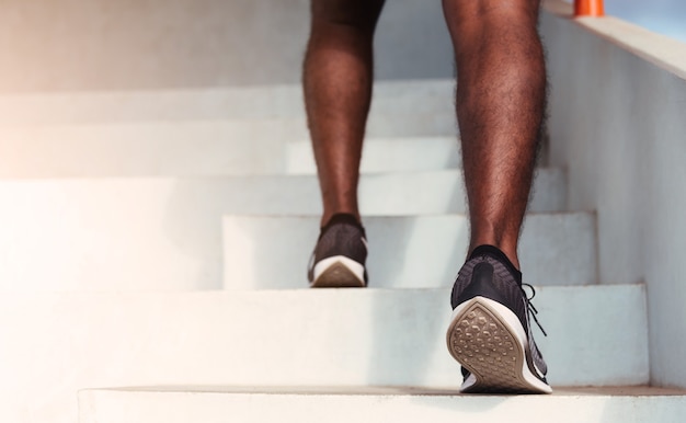 Close-up van atleet schoenen van benen loper man stap aangelopen traplopen doen cardio sport training op de buiten