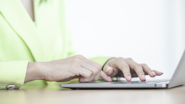 Close-up van aziatische zakenvrouw die computerlaptop gebruikt Zakelijke aziatische vrouw die op kantoor werkt, gebruik van computerlaptop Zakenvrouw die werkt en typt op het toetsenbord van de laptop in kantoor