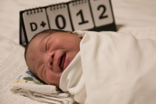 Foto close-up van baby meisje liggend op bed