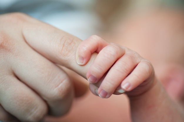 Close-up van baby&#39;s hand met moeders vinger met tederheid