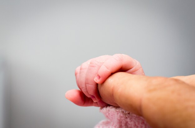 Close-up van baby&#39;s hand met vaders vinger