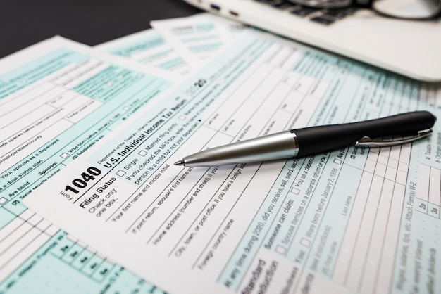 Close-up van belastingformulier 1040 met een pen en een notitieboekje op een zwarte achtergrond