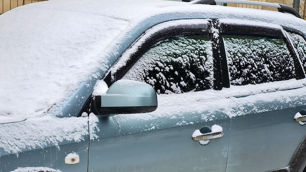 Close-up van besneeuwde suv-auto onder sneeuwstorm Koude winter ijzig besneeuwde achtergrond