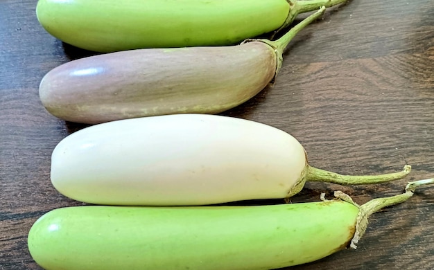 Close-up van biologische witte en groene verse aubergine of eierplant geïsoleerd op houten achtergrond