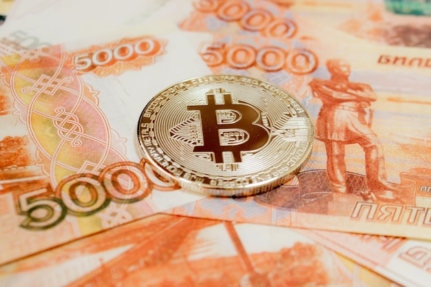 Close-up van Bitcoin munten op 5000 Russische roebel bankbiljet. Cryptovaluta BTC.