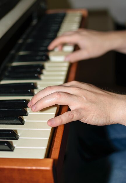 Close-up van blanke handen die elektrische piano spelen in de slaapkamer