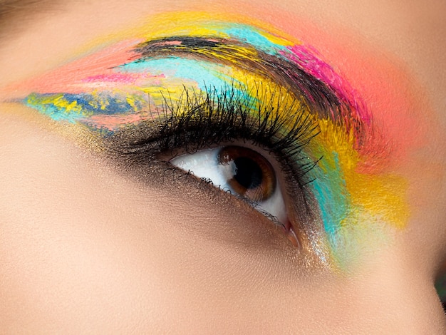 Close-up van blauw vrouw oog met mooie bruin met rode en oranje tinten smokey eyes make-up. Moderne mode-make-up.