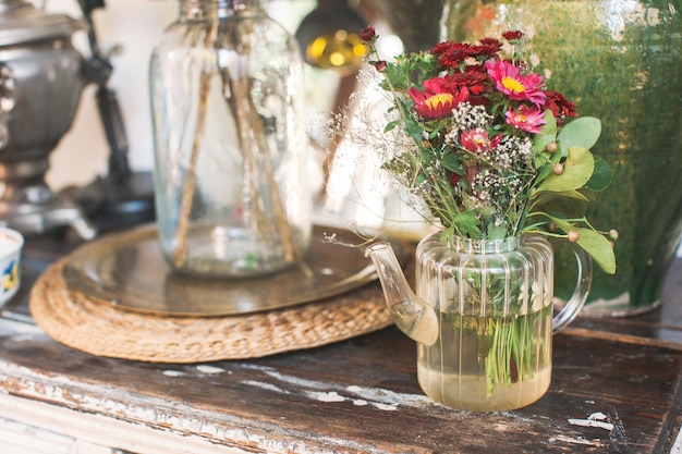 Foto close-up van bloemen in een glazen pot op tafel