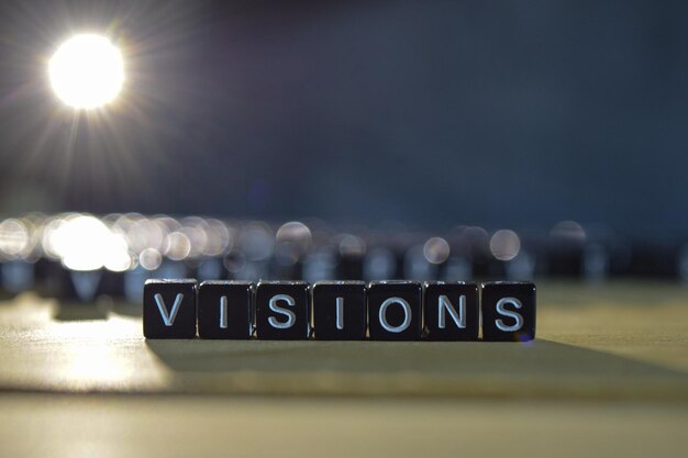 Close-up van blokken met visie tekst op tafel tegen verlichte gloeilamp