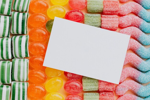 Close-up van boven van een witte papieren kaart samengesteld uit rijen heerlijke karamel gummy jelly snoepjes